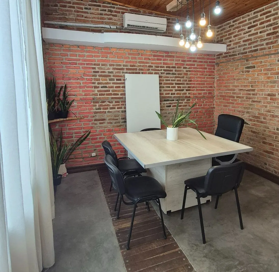 Sala Sinergia: espacio tipo loft con mesa y plantas